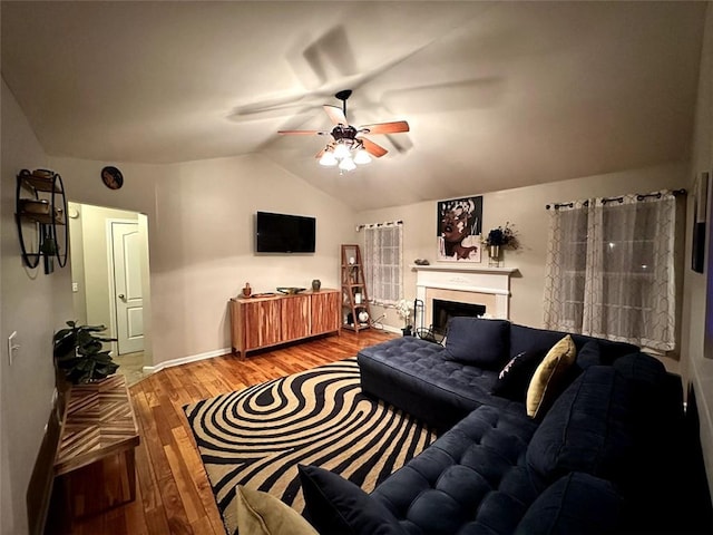 living room featuring ceiling fan, vaulted ceiling, and light hardwood / wood-style flooring