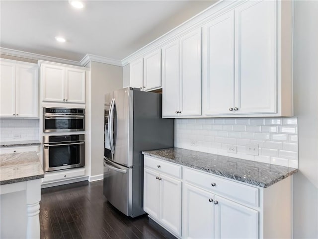 4905 Sterling Close, Buford, GA 30518 - kitchen with appliances with stainless steel finishes, white cabinetry, dark wood-style floors, light stone counters, and backsplash