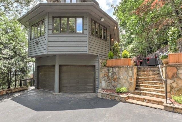 73 Falcon Heights Ln, Big Canoe, GA 30143 - view of property exterior with stairway, an attached garage, and asphalt driveway