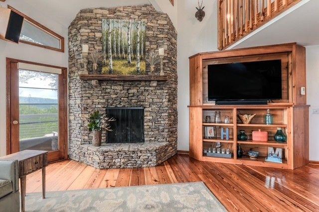 73 Falcon Heights Ln, Big Canoe, GA 30143 - living room with wood finished floors and a stone fireplace