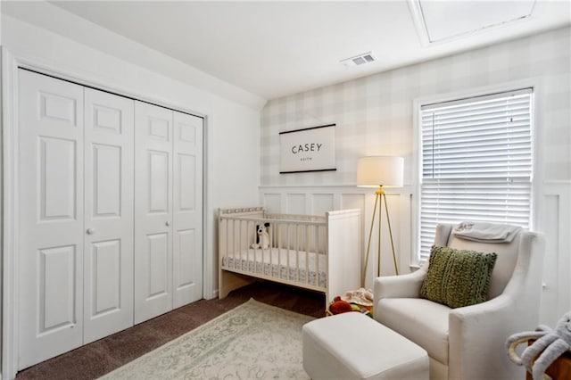 carpeted bedroom with a nursery area and a closet