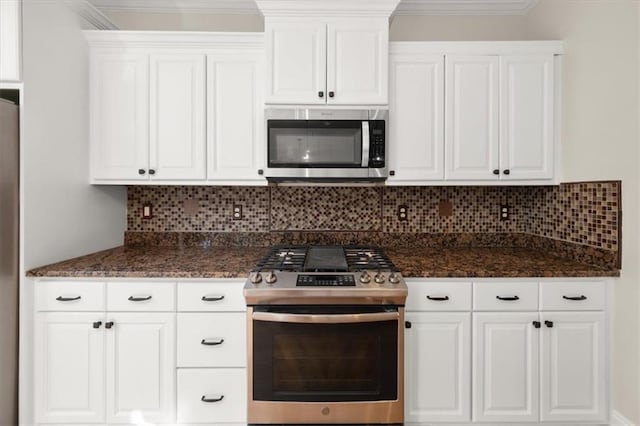 kitchen with white cabinets, appliances with stainless steel finishes, and tasteful backsplash