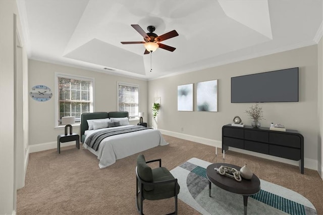 carpeted bedroom with a raised ceiling, ceiling fan, and crown molding