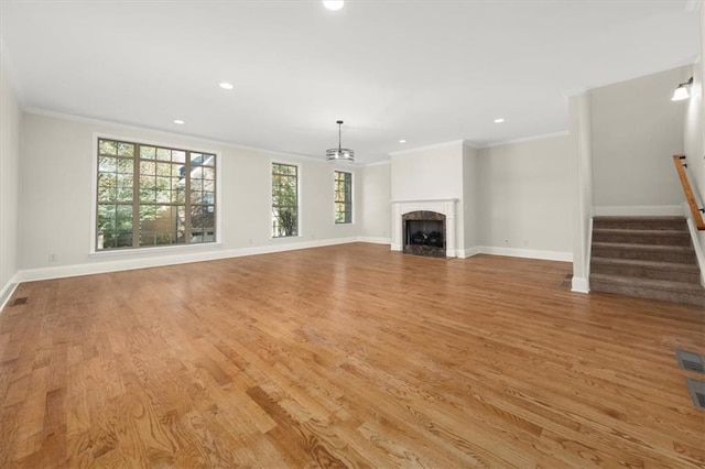 unfurnished living room featuring light hardwood / wood-style floors and ornamental molding