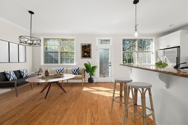 dining room featuring light wood-type flooring, breakfast area, a chandelier, and plenty of natural light