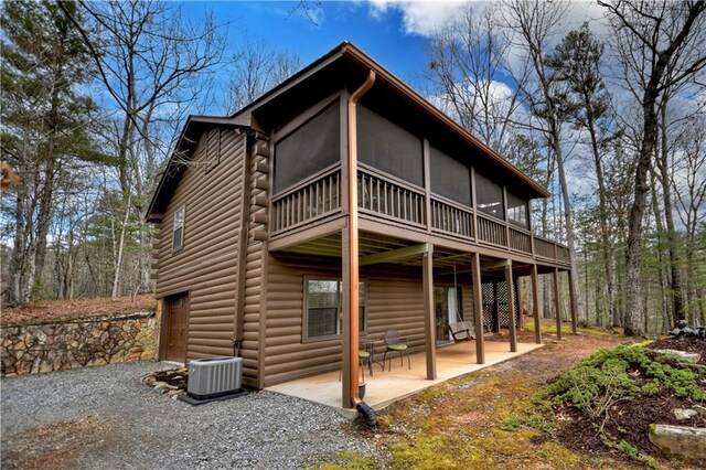 97 Doyle Carder Pkwy, Blue Ridge, GA 30513 - rear view of house with central AC, log exterior, a patio area, and a sunroom