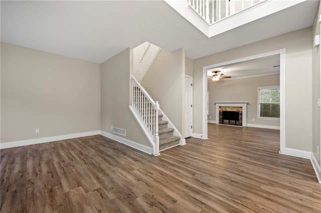 unfurnished living room with wood-type flooring and ceiling fan