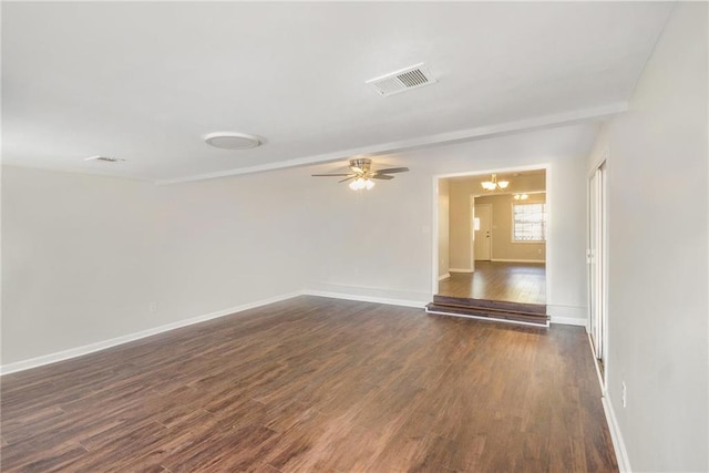 spare room with dark wood finished floors, a ceiling fan, and baseboards