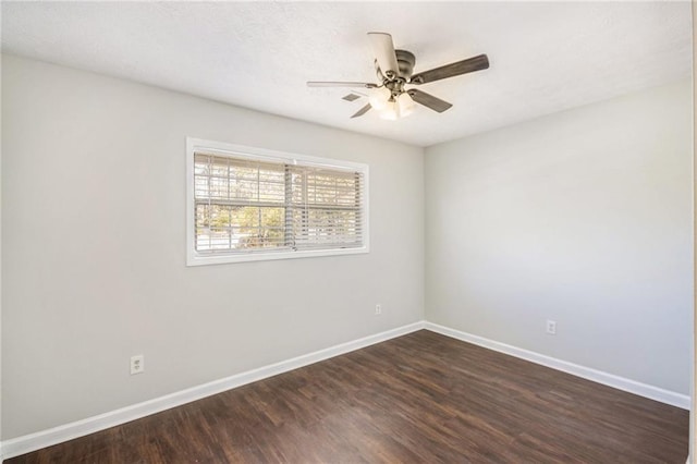 spare room featuring dark wood finished floors, baseboards, and a ceiling fan