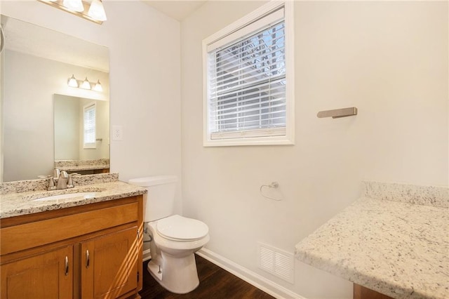 bathroom with wood finished floors, baseboards, toilet, and vanity