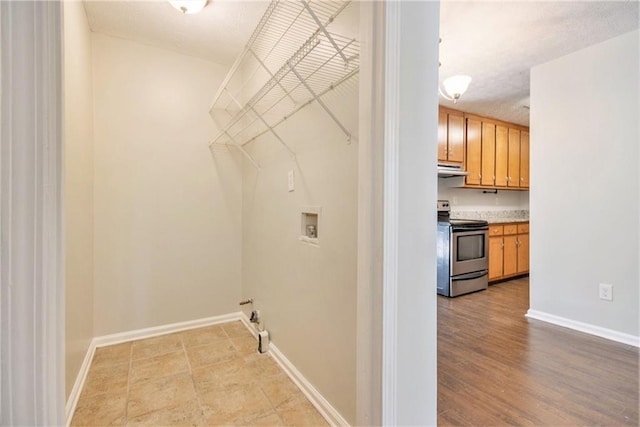 laundry room featuring washer hookup and baseboards
