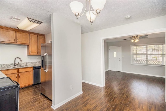 kitchen with appliances with stainless steel finishes, a sink, dark wood-type flooring, brown cabinetry, and baseboards