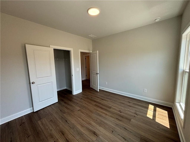 unfurnished bedroom featuring a closet and dark hardwood / wood-style floors