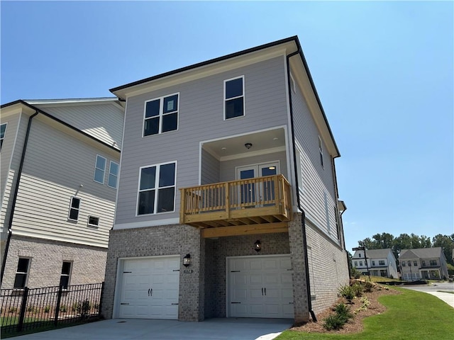 rear view of house featuring a garage and a balcony