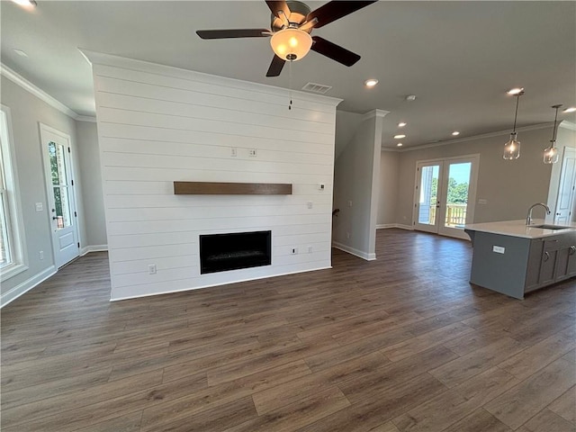 unfurnished living room featuring ceiling fan, sink, french doors, dark wood-type flooring, and crown molding