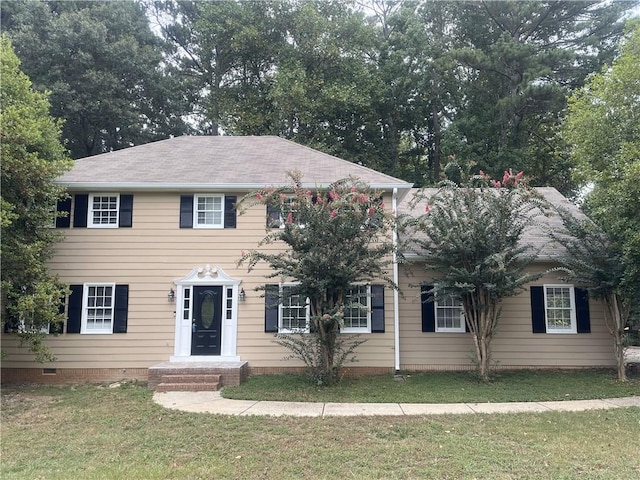 colonial home featuring a front lawn