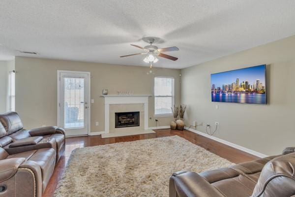 living room featuring plenty of natural light, a ceiling fan, wood finished floors, and baseboards