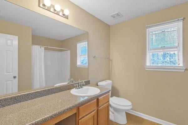 full bathroom with toilet, baseboards, visible vents, a shower with shower curtain, and vanity