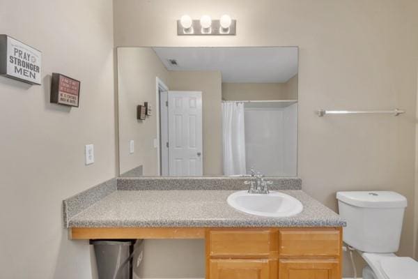 bathroom with vanity, a shower with shower curtain, and toilet