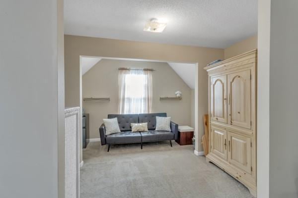 living area featuring light colored carpet and lofted ceiling