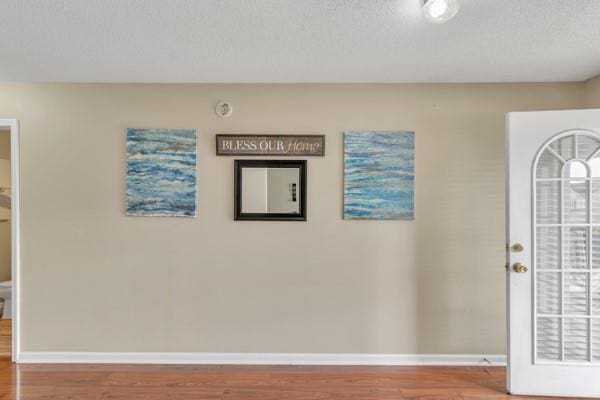 foyer entrance featuring baseboards and wood finished floors