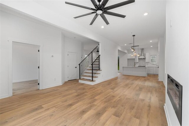 kitchen featuring a kitchen island, decorative light fixtures, white cabinetry, decorative backsplash, and light hardwood / wood-style flooring