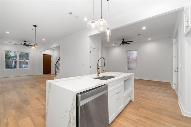 unfurnished living room featuring sink, light wood-type flooring, french doors, ceiling fan, and plenty of natural light