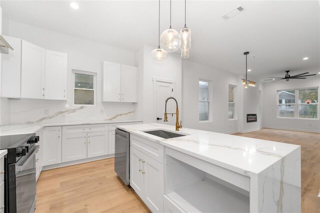 kitchen featuring sink, white cabinets, decorative light fixtures, and light hardwood / wood-style floors