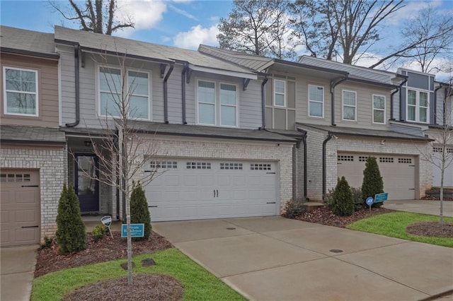 townhome / multi-family property with brick siding, concrete driveway, and an attached garage