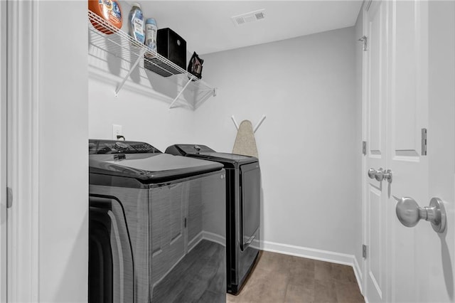 washroom featuring wood finished floors, visible vents, baseboards, laundry area, and independent washer and dryer