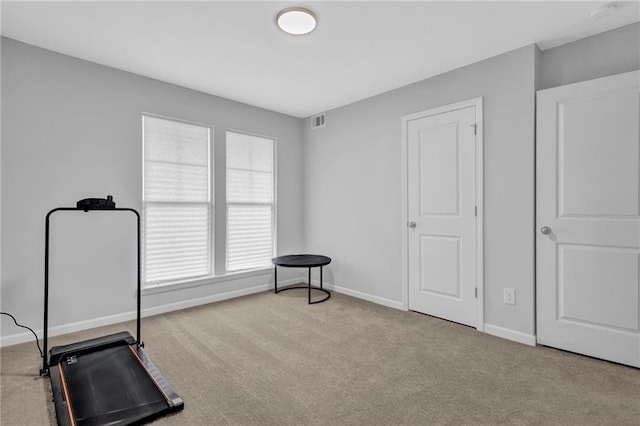 exercise room featuring baseboards, visible vents, and carpet floors