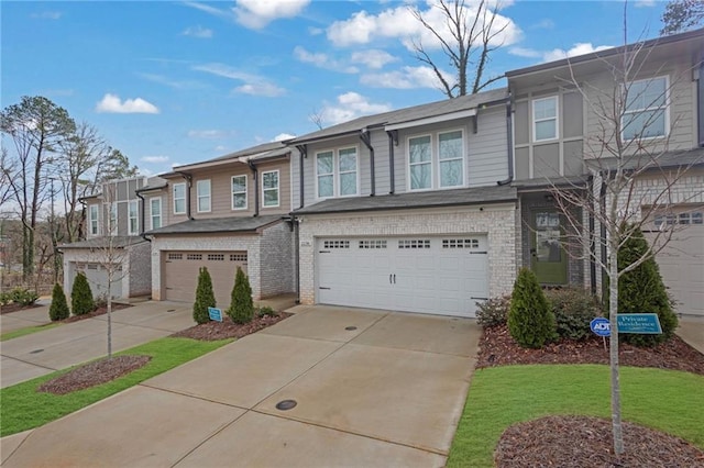 townhome / multi-family property featuring brick siding, a garage, and driveway