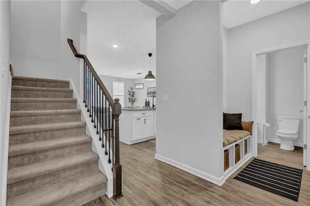 staircase featuring recessed lighting, baseboards, and wood finished floors