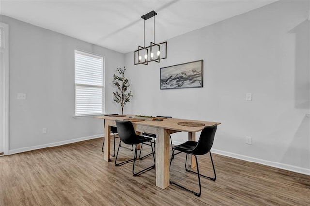 dining room with an inviting chandelier, wood finished floors, and baseboards