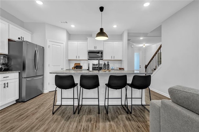 kitchen featuring visible vents, dark wood-type flooring, appliances with stainless steel finishes, and white cabinets