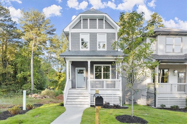 view of front of home featuring covered porch and a front lawn