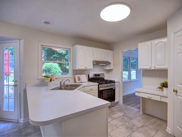 750 Whitehall Way, Roswell, GA 30076 - kitchen with stainless steel gas range oven, under cabinet range hood, light countertops, white cabinetry, and a peninsula