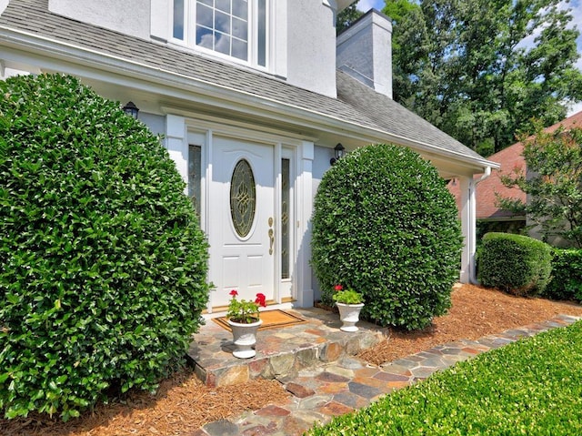 750 Whitehall Way, Roswell, GA 30076 - view of exterior entry with stucco siding, a chimney, and a shingled roof
