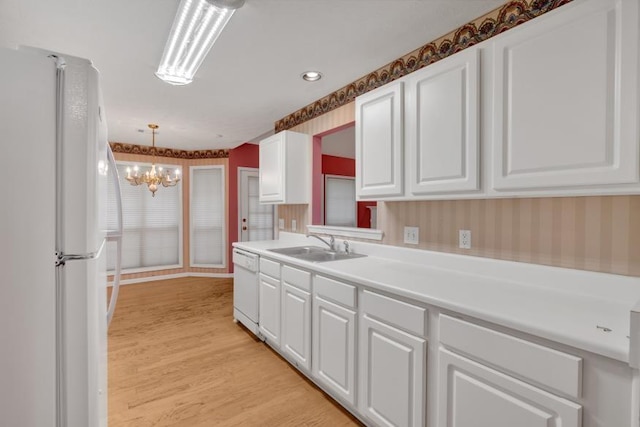 209 Southerness Ct, Stockbridge, GA 30281 - kitchen featuring white appliances, white cabinetry, a chandelier, light wood-style flooring, and light countertops