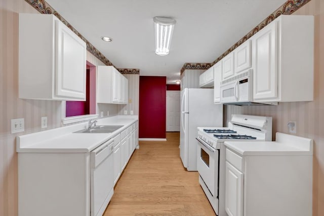 209 Southerness Ct, Stockbridge, GA 30281 - kitchen with white appliances, wallpapered walls, light wood-style flooring, white cabinetry, and light countertops