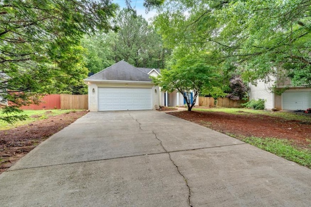 209 Southerness Ct, Stockbridge, GA 30281 - view of property hidden behind natural elements with concrete driveway, an attached garage, stucco siding, and a shingled roof