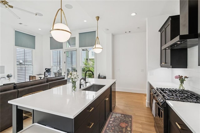 kitchen with gas range, wall chimney exhaust hood, healthy amount of natural light, light countertops, and recessed lighting