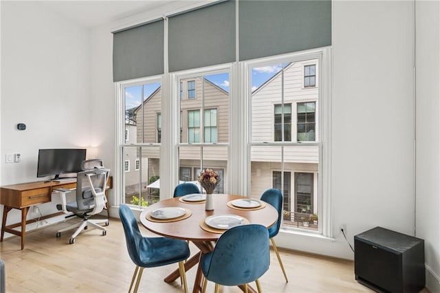dining space with light wood-style flooring and an office area
