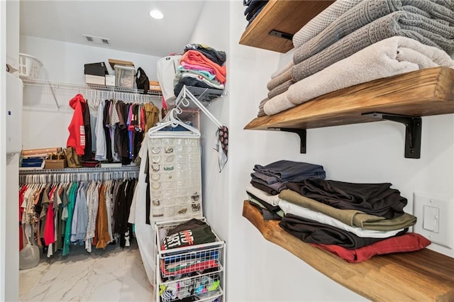 spacious closet with marble look tile flooring