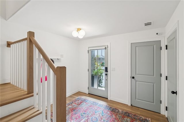 foyer entrance with wood finished floors and stairway