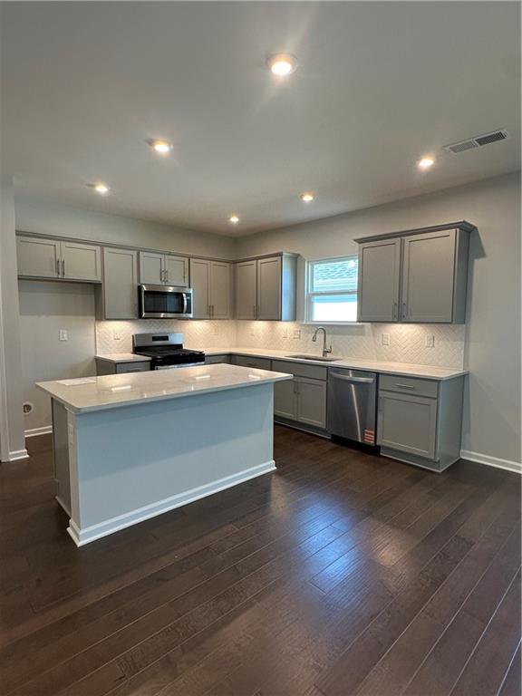 861 Pineberry Ct, Grayson, GA 30017 - kitchen featuring stainless steel appliances, gray cabinetry, a kitchen island, light countertops, and recessed lighting
