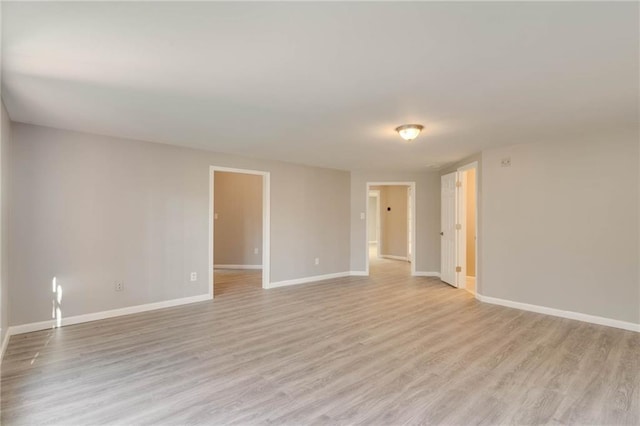 unfurnished room featuring baseboards and light wood finished floors