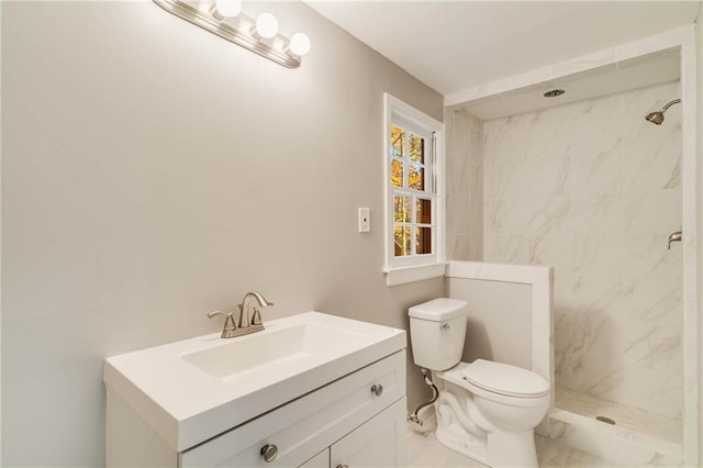bathroom featuring marble finish floor, toilet, vanity, and a marble finish shower