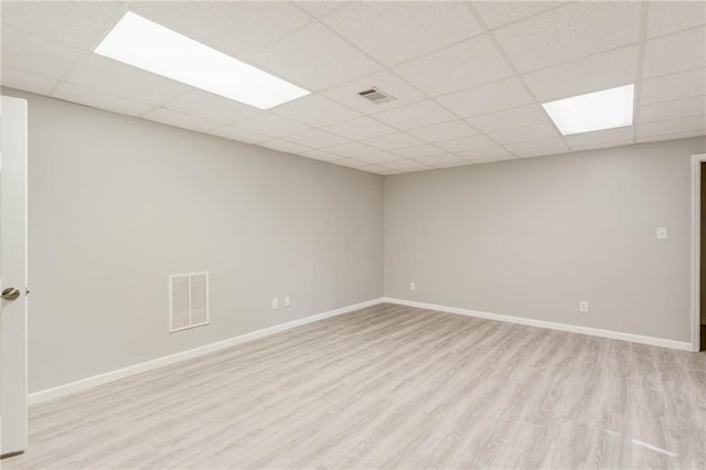 unfurnished room with a paneled ceiling, light wood-style flooring, and visible vents