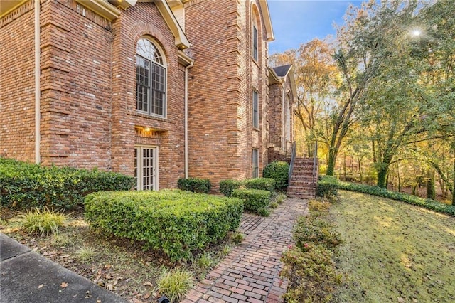 view of side of property featuring brick siding and stairs
